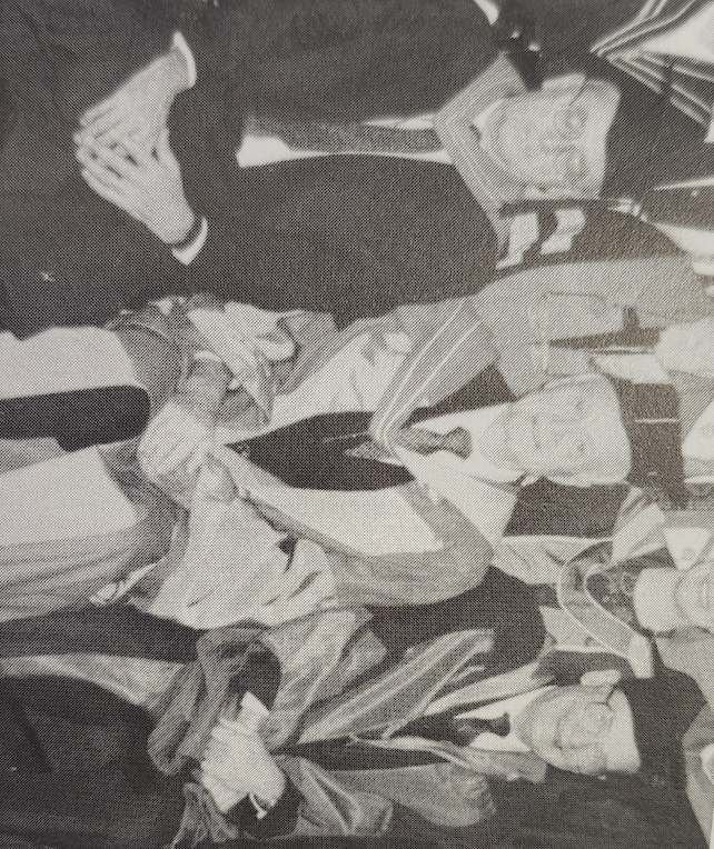 A black and white photo of three men, in ceremonial robes, sitting down. 